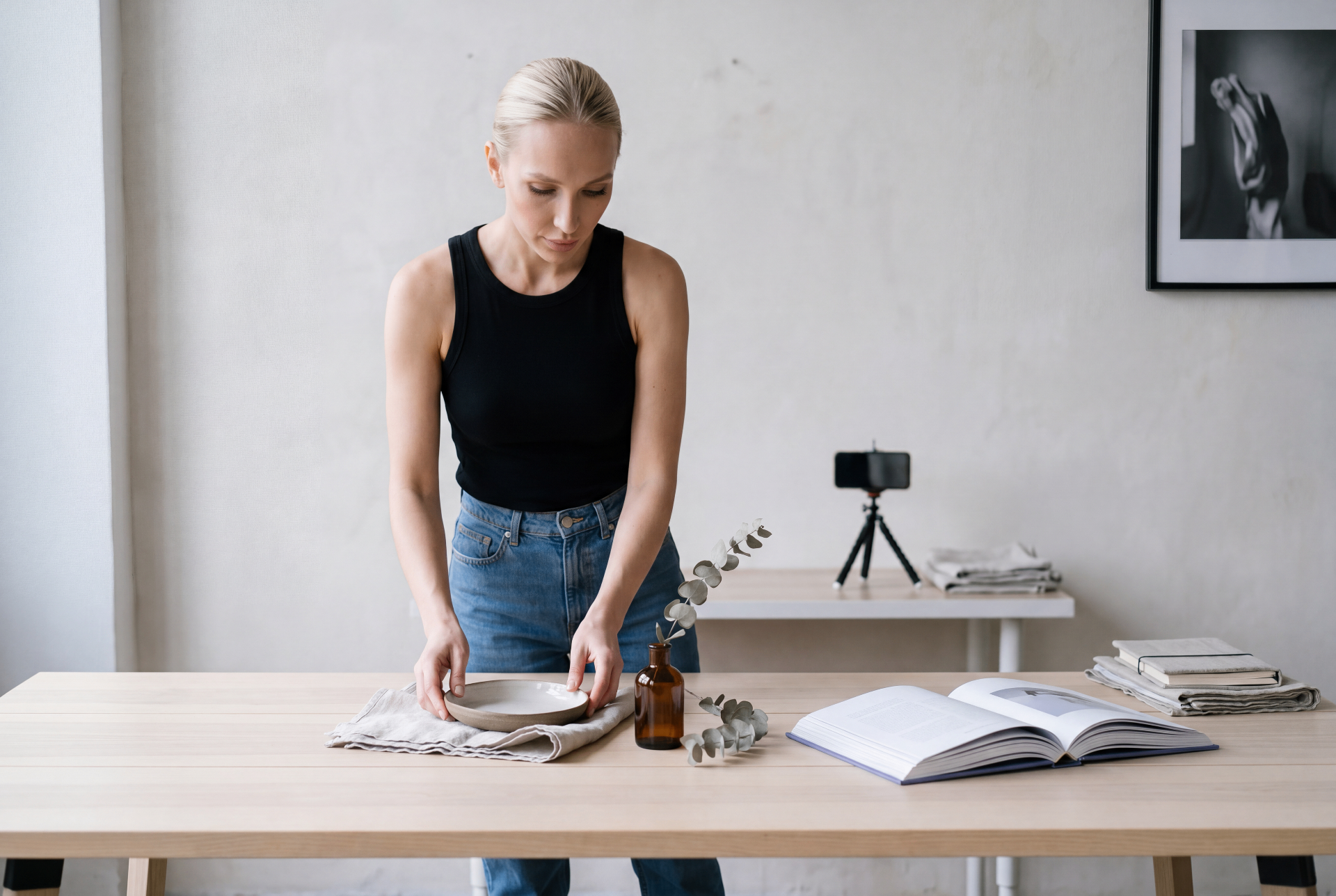 Taryn styling a ceramic bowl and linen on a wood table in a quiet studio